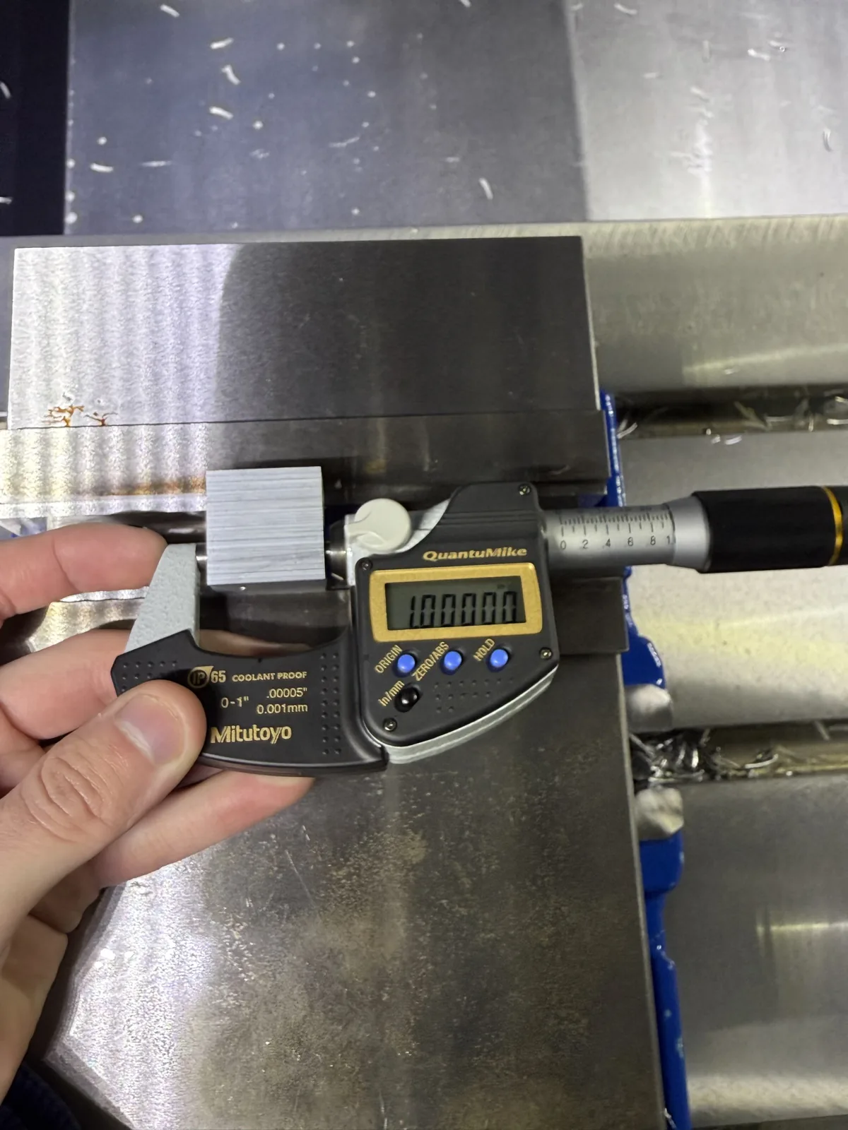 Precision measurement of a CNC machined part using calipers and inspection tools