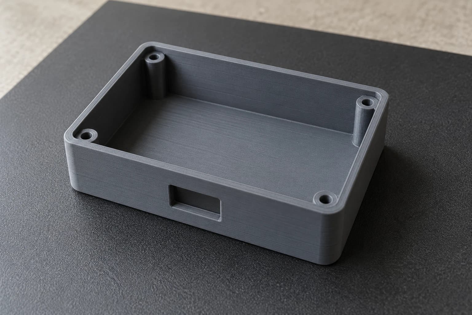 Gray PETG enclosure printed with FDM, with four internal bosses and a connector opening