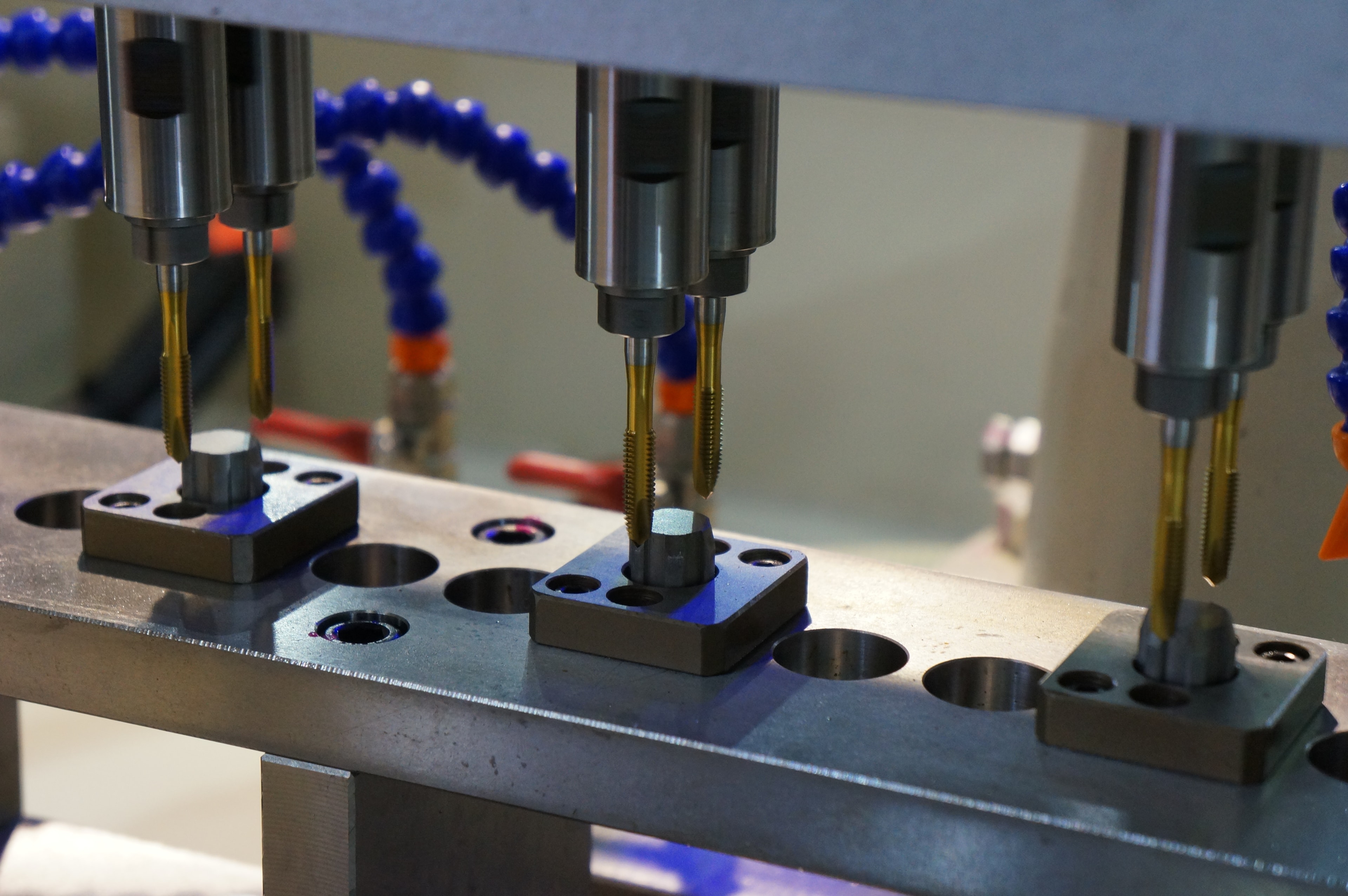 CNC drilling and threading process producing precision holes and tapped features in metal components