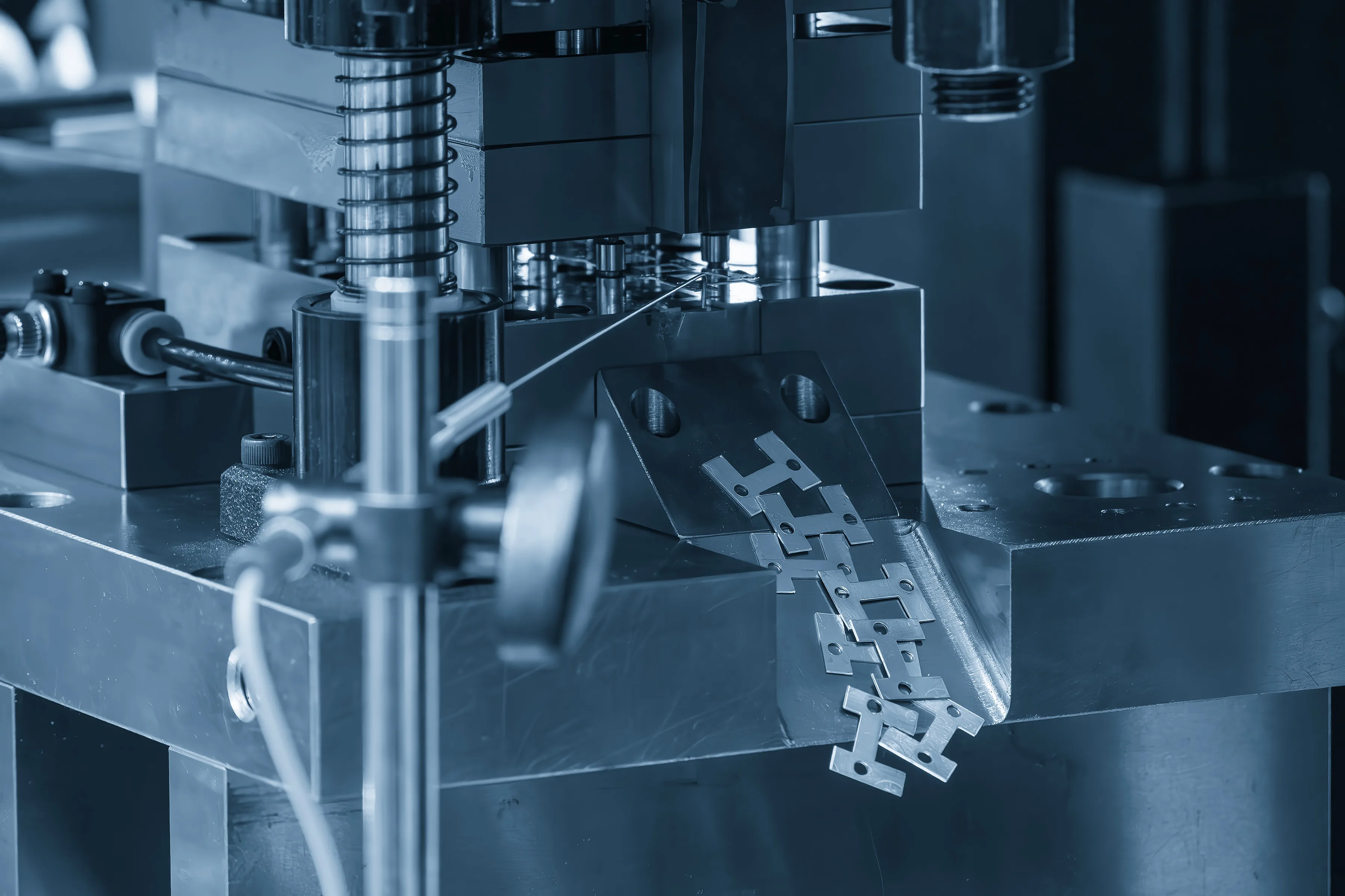 Precision metal stamping process forming custom metal components with progressive die tooling