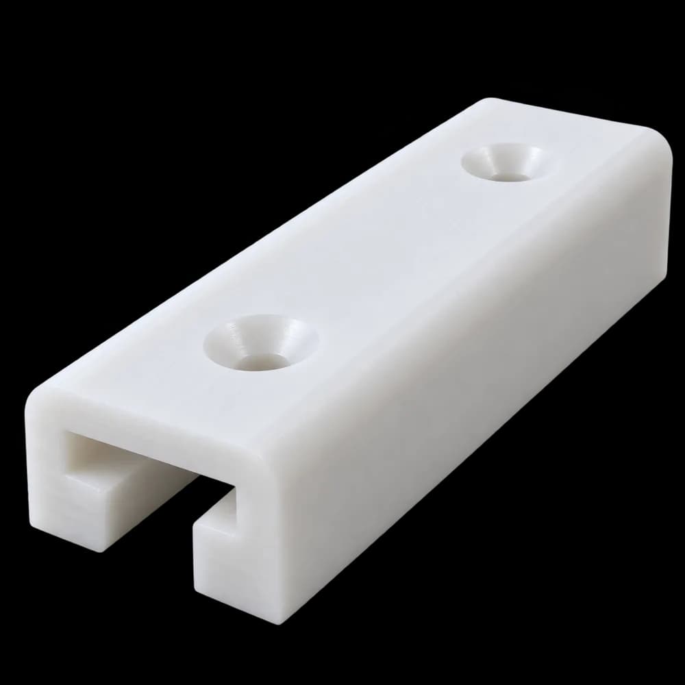 CNC milled white HDPE slide pad with a T-slot and two countersunk holes