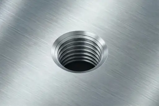 Close-up of CNC part with machined threads and metal inserts